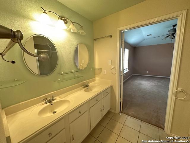 bathroom featuring tile patterned floors, vaulted ceiling, ceiling fan, and vanity