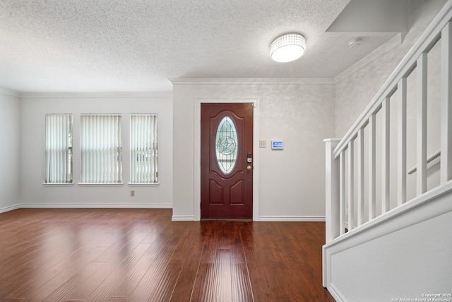 entrance foyer with crown molding, dark hardwood / wood-style floors, and a textured ceiling