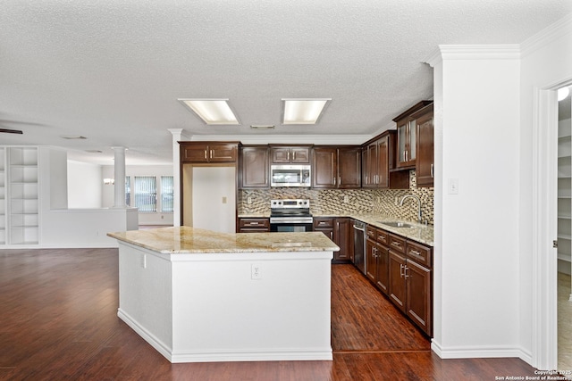 kitchen featuring stainless steel appliances, a center island, light stone countertops, sink, and dark hardwood / wood-style floors