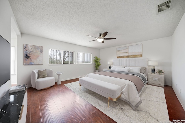 bedroom with hardwood / wood-style floors, ceiling fan, and a textured ceiling