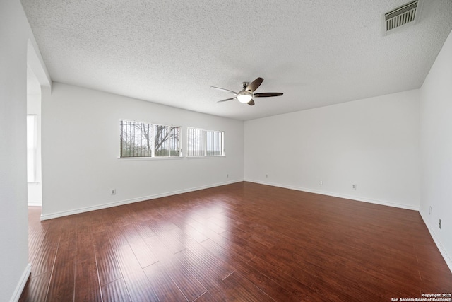 unfurnished room featuring ceiling fan, dark wood-type flooring, and a textured ceiling