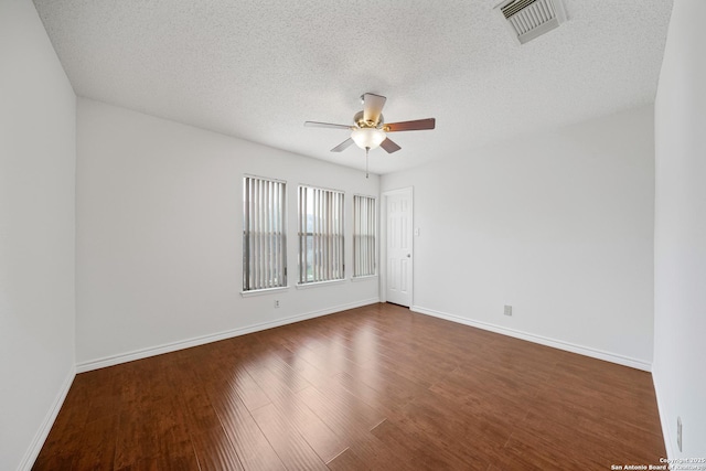 unfurnished room with a textured ceiling, dark wood-type flooring, and ceiling fan