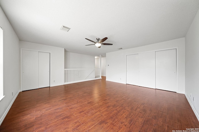 unfurnished bedroom featuring a textured ceiling, ceiling fan, and dark hardwood / wood-style floors