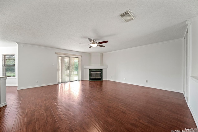 unfurnished living room featuring ceiling fan, dark hardwood / wood-style flooring, a textured ceiling, and crown molding