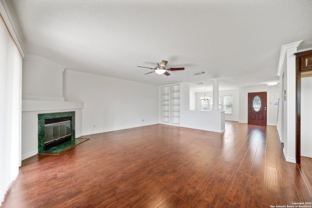 unfurnished living room featuring ceiling fan with notable chandelier, a tiled fireplace, a textured ceiling, and hardwood / wood-style flooring