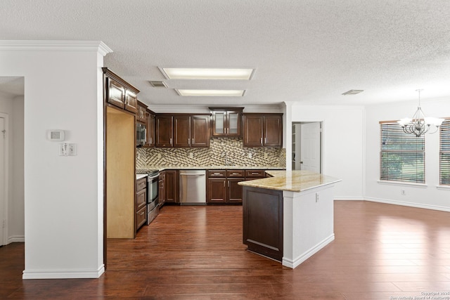 kitchen featuring dark wood-type flooring, stainless steel appliances, dark brown cabinetry, light stone counters, and decorative light fixtures