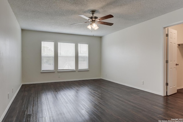 spare room with dark wood-style floors, a textured ceiling, baseboards, and a ceiling fan