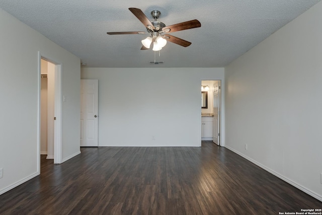 spare room featuring dark wood-style floors, visible vents, a textured ceiling, and a ceiling fan