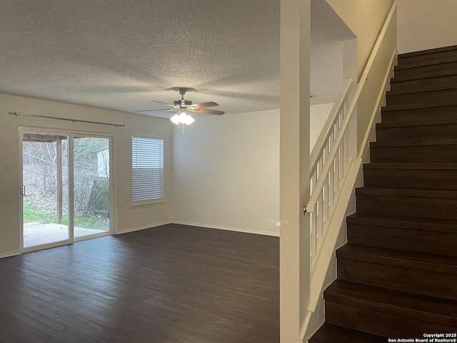 interior space with ceiling fan, a textured ceiling, baseboards, and wood finished floors