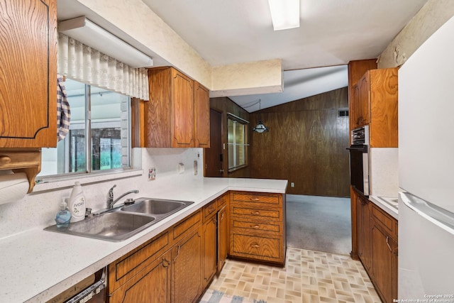 kitchen with oven, light countertops, a sink, and freestanding refrigerator