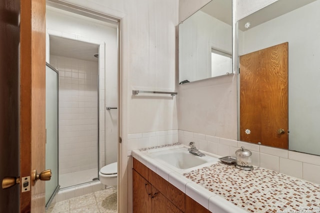 full bath featuring a stall shower, backsplash, vanity, and toilet