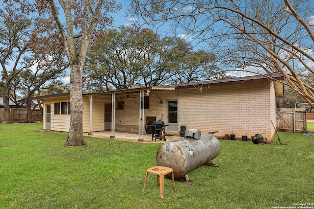 back of house with a patio area, brick siding, fence, and a lawn