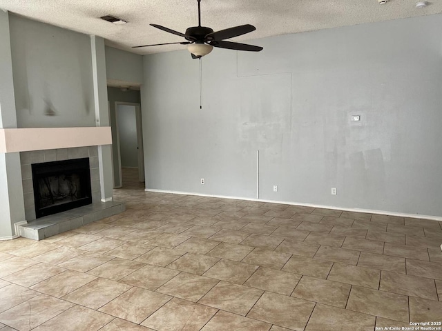 unfurnished living room featuring a textured ceiling, a tile fireplace, vaulted ceiling, and ceiling fan