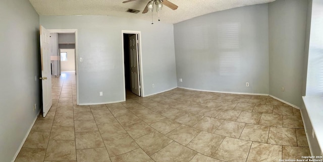 empty room featuring light tile patterned floors, ceiling fan, and a textured ceiling