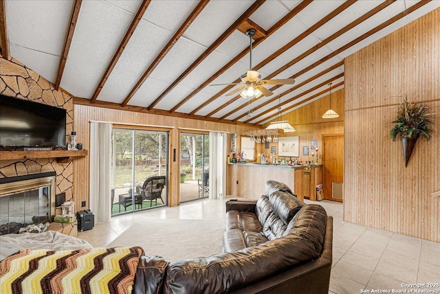 tiled living room featuring high vaulted ceiling, ceiling fan, wood walls, a fireplace, and beamed ceiling