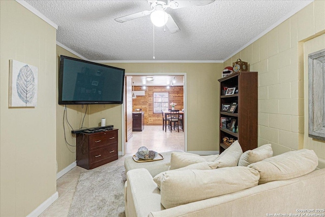 living room with ceiling fan, a textured ceiling, wooden walls, and ornamental molding