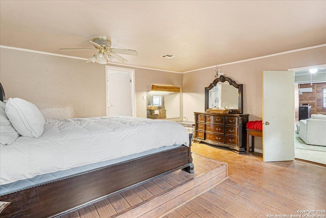 bedroom featuring ceiling fan, ornamental molding, and light hardwood / wood-style floors