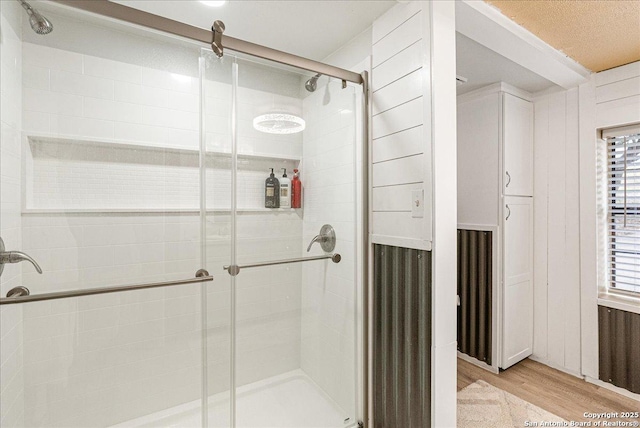 bathroom featuring hardwood / wood-style flooring and a shower with door