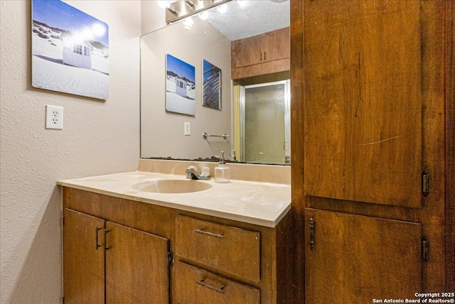 bathroom featuring vanity and a shower with door