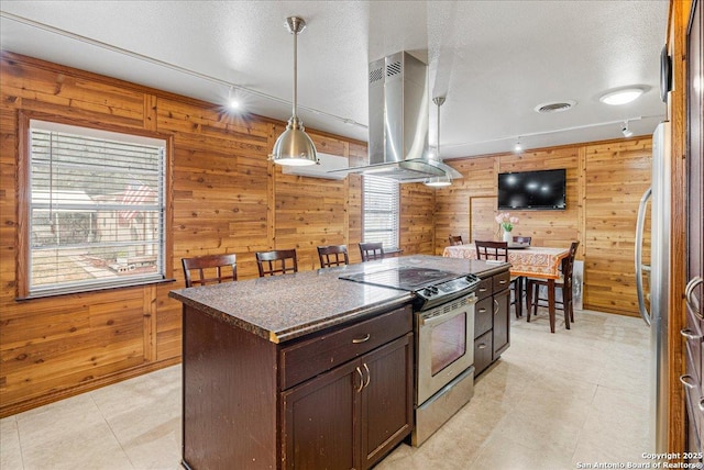 kitchen with appliances with stainless steel finishes, island exhaust hood, a center island, hanging light fixtures, and dark brown cabinets