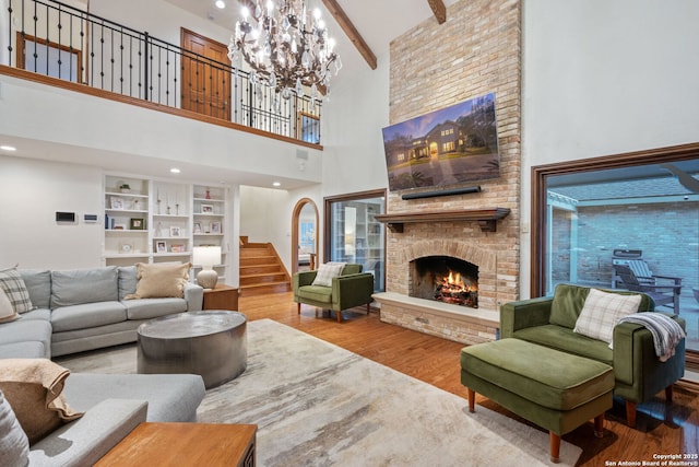 living room with a fireplace, hardwood / wood-style floors, a high ceiling, and beamed ceiling