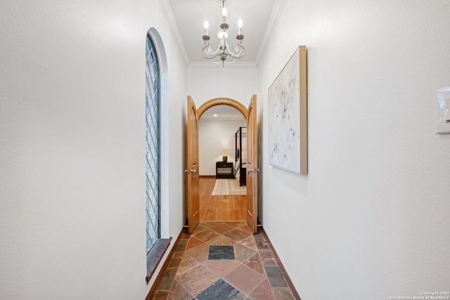 corridor featuring a chandelier and crown molding