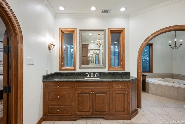 bathroom with a chandelier, vanity, ornamental molding, and tiled tub