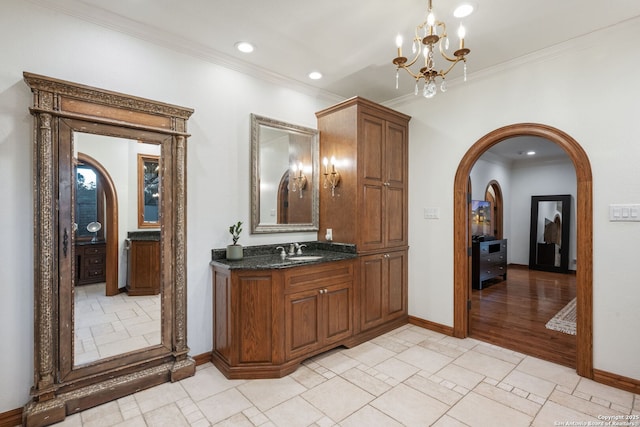 bar with sink, dark stone counters, and ornamental molding