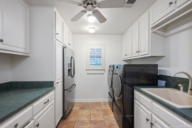 washroom with ceiling fan, cabinets, sink, and washing machine and clothes dryer