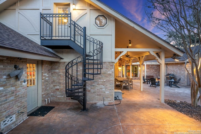 exterior entry at dusk featuring ceiling fan and a patio