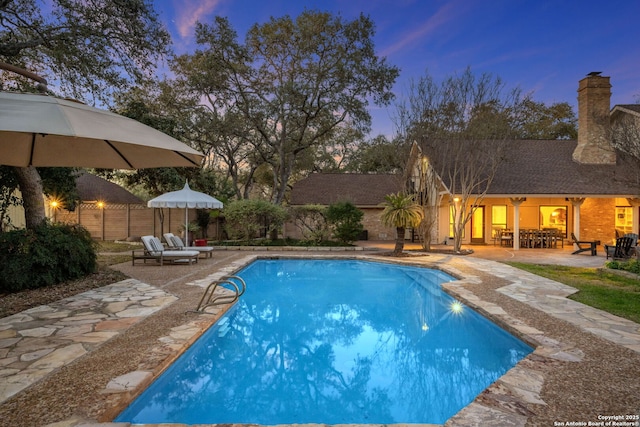 pool at dusk with a patio