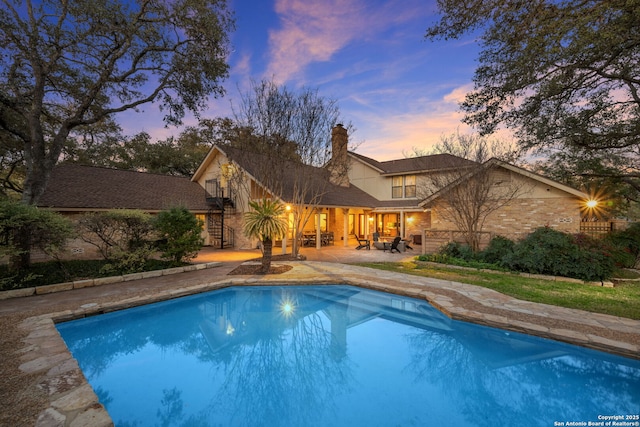 pool at dusk with a patio