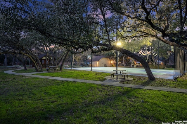 view of community featuring a yard and basketball hoop