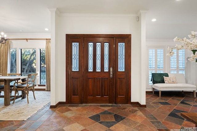 entryway featuring a notable chandelier, plenty of natural light, and crown molding