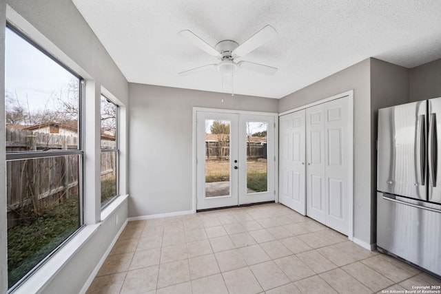 unfurnished sunroom featuring ceiling fan and french doors