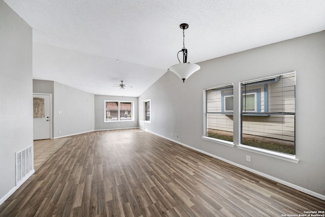 unfurnished living room with hardwood / wood-style floors, lofted ceiling, ceiling fan, and a textured ceiling