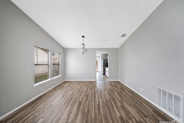 interior space featuring vaulted ceiling and dark wood-type flooring