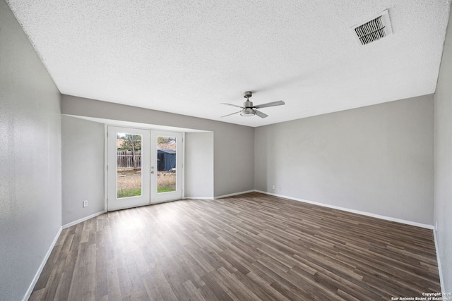 spare room featuring ceiling fan, french doors, dark wood-type flooring, and a textured ceiling