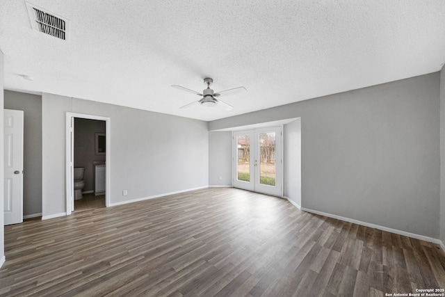 empty room with a textured ceiling, french doors, dark wood-type flooring, and ceiling fan