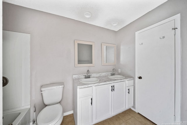 bathroom with a textured ceiling, vanity, toilet, and tile patterned flooring