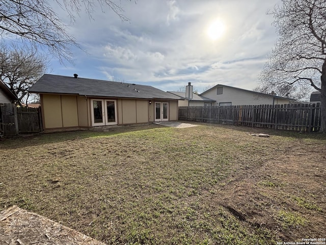 rear view of house featuring a patio area, french doors, and a lawn