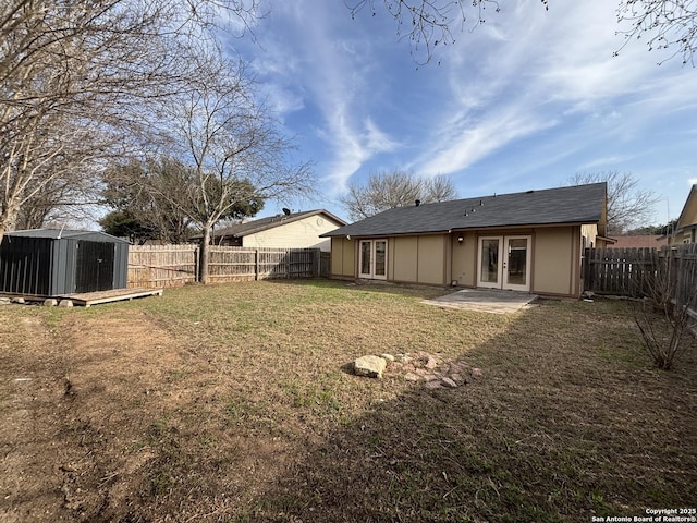 rear view of house featuring a patio, french doors, a yard, and a shed