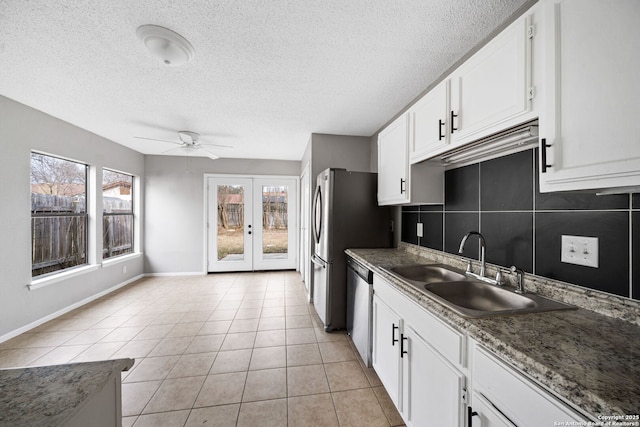 kitchen featuring french doors, sink, stainless steel dishwasher, white cabinets, and light tile patterned flooring