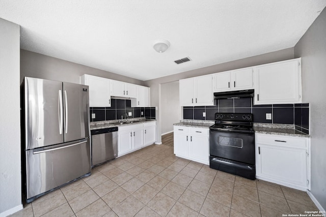 kitchen featuring stainless steel appliances, light stone countertops, decorative backsplash, sink, and white cabinetry