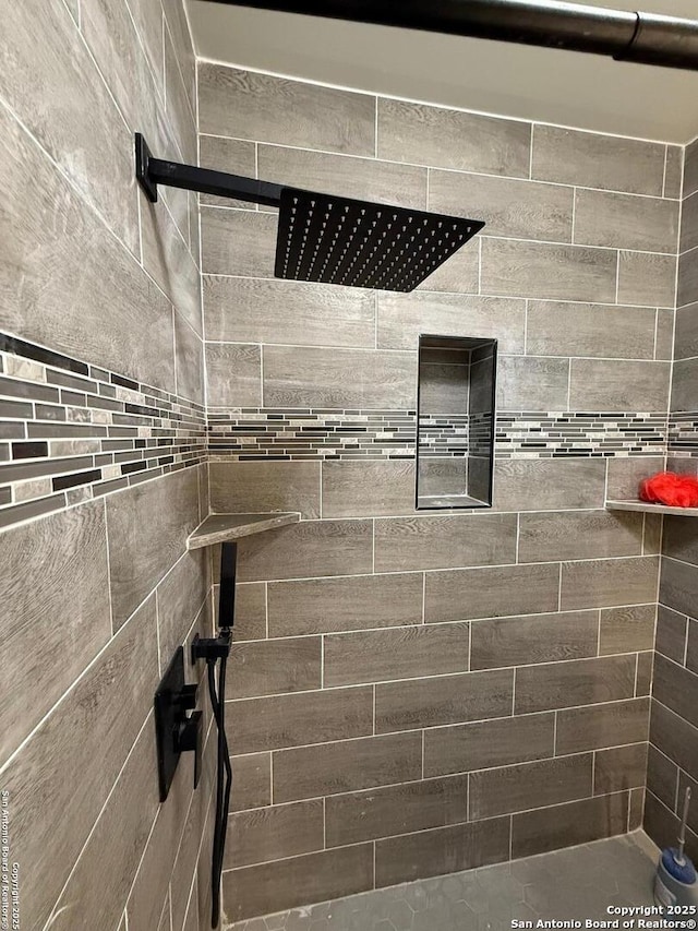 interior details featuring a tile shower