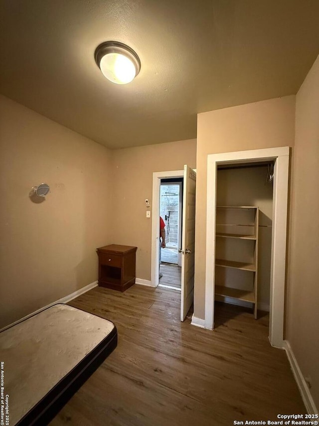 unfurnished bedroom featuring a closet and dark hardwood / wood-style flooring