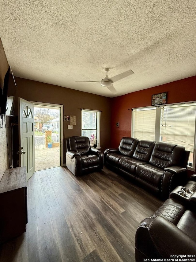 living room featuring ceiling fan, a textured ceiling, and hardwood / wood-style floors