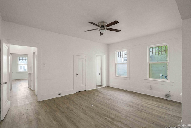 unfurnished room featuring ceiling fan, plenty of natural light, and wood-type flooring