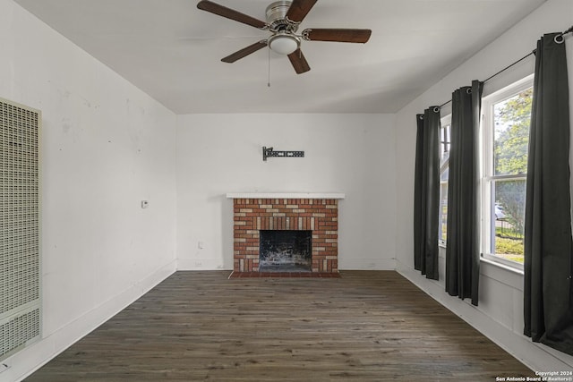 unfurnished living room featuring a fireplace, vaulted ceiling, dark hardwood / wood-style floors, and a healthy amount of sunlight