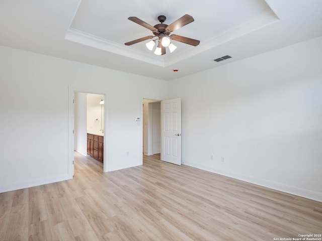 unfurnished bedroom with a tray ceiling, ceiling fan, light hardwood / wood-style floors, and ornamental molding